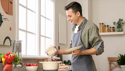 Young,Man,Cooking,Food,In,Kitchen