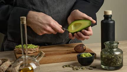 Man,Cook,Making,Avocado,Sandwiches,On,A,Wooden,Table.,Healthy