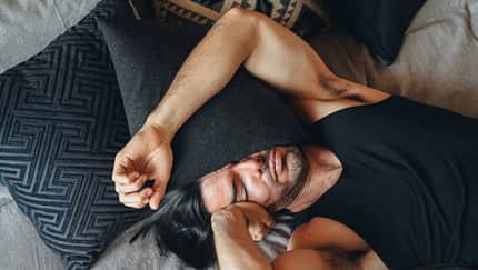 Mann, der sich unwohl fühlt, liegt im Bett