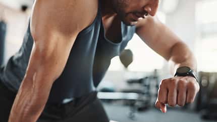 Mann schaut auf Fitnessuhr