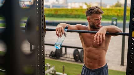 Gym,Enthusiast,Muscular,Man,Resting,After,A,Workout,,Leaning,On