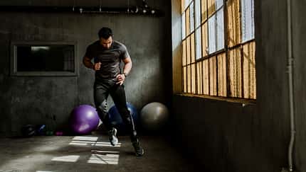 Sportlicher Mann, der in einem Fitnessstudio einen Seitwärtssprung macht