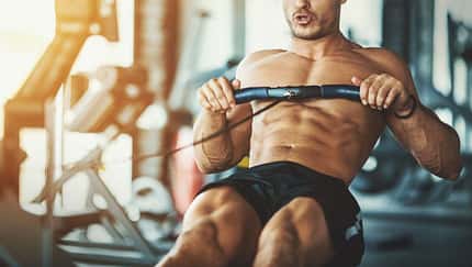 Ein trainierter Mann führt im Gym die Übung "Rudern" aus