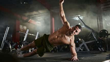 Ein Mann, der eine seitliche hohe Planke macht