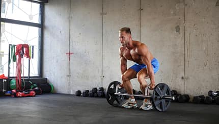 Ein kräftiger Mann beim Kreuzheben mit einer Langhantel Ein kräftiger Mann beim Kreuzheben mit einer Langhantel