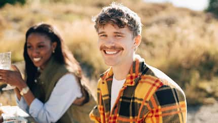 Portrait of happy young man with mustache at dinner party during social gathering