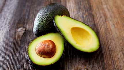 Aufgeschnittene Avocados auf Holzhintergrund Aufgeschnittene Avocados auf Holzhintergrund