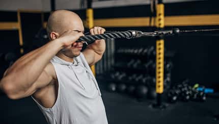 Ein Mann macht Face Pulls an einer Maschine Ein Mann macht Face Pulls an einer Maschine