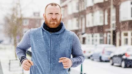 Ein Mann joggt mit einem Pulli im Winter Ein Mann joggt mit einem Pulli im Winter