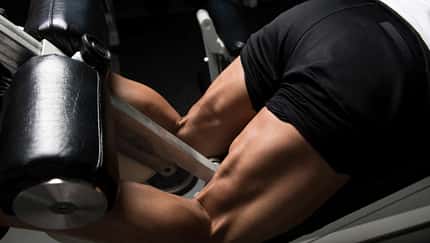 Männliche Beine am Beinstrecker 