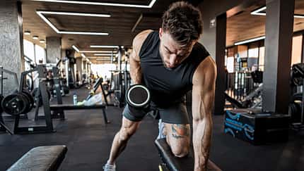 activity Fit Man Exercising with Dumbbells at Gym