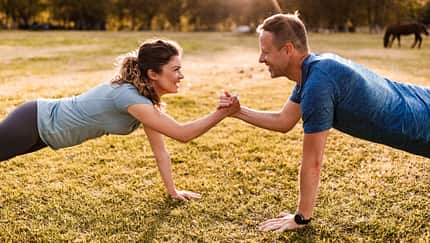 Happy athletic couple cooperating while exercising strength in nature. Happy athletic couple cooperating while exercising strength in nature.