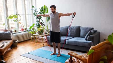 Man watching online videos and doing exercise at home