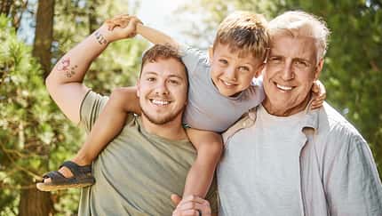 Sohn, Vater und Großvater lächeln in die Kamera