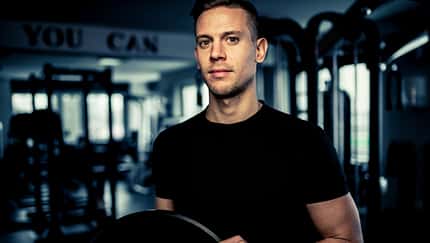 Ein junger Mann hält Gewichte im Gym