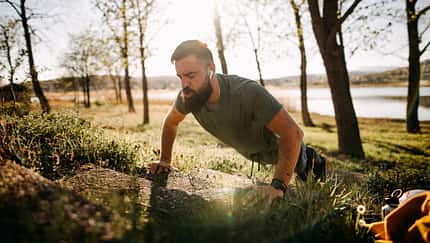 Ein Mann macht draußen erhöhte Liegestütze
