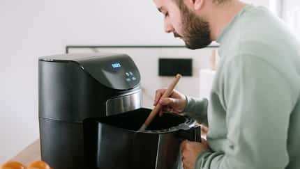 Ein Mann kocht im Airfryer