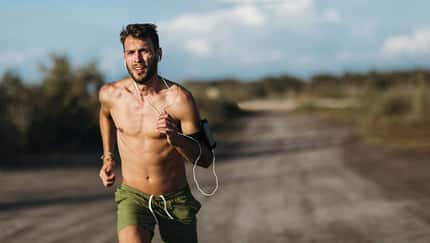 Ein junger Mann joggt oberkörperfrei in der sommerlichen Hitze