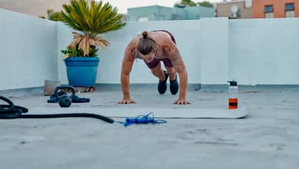 Ein Mann macht draußen oberkörperfrei Burpees Ein Mann macht draußen oberkörperfrei Burpees