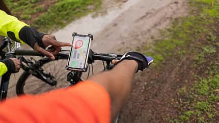 Smartphone ist am Fahrradlenker angebracht und eine Navigationsapp ist geöffnet Smartphone ist am Fahrradlenker angebracht und eine Navigationsapp ist geöffnet