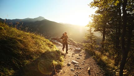 Ein Mann wandert in einer sonnigen Berglandschaft. Ein Mann wandert in einer sonnigen Berglandschaft.