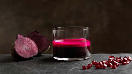 Ein Glas Rote Beete Saft vor dunklem Hintergrund