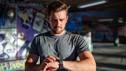 Ein Mann checkt seine Fitnessuhr Ein Mann checkt seine Fitnessuhr