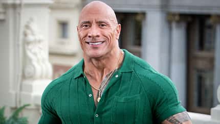 Dwayne Johnson lächelt im grünen Oberteil in die Kamera Dwayne Johnson lächelt im grünen Oberteil in die Kamera