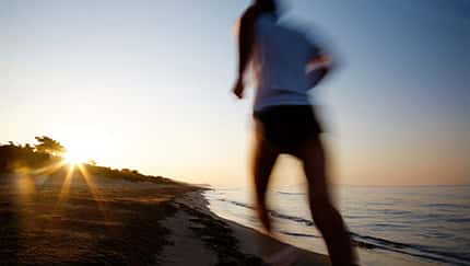 Läufer am Strand beim Sonnenuntergang Läufer am Strand beim Sonnenuntergang