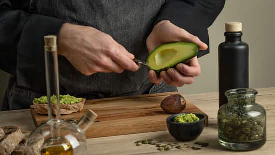 Man,Cook,Making,Avocado,Sandwiches,On,A,Wooden,Table.,Healthy