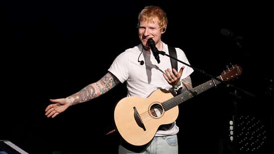 Ed Sheeran mit seiner Gitarre am Mikrofon