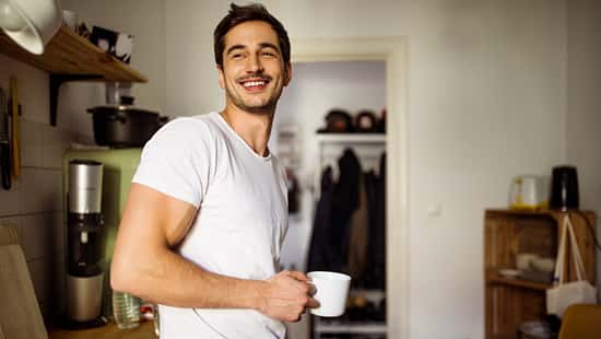 Young man in kitchen with coffee