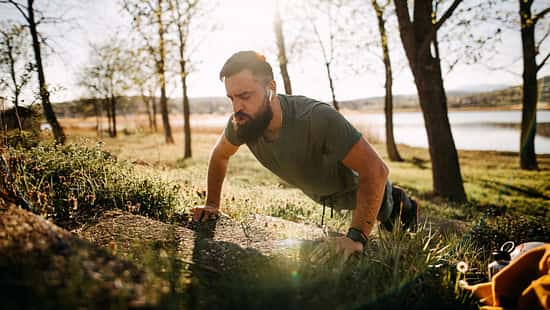 Ein Mann macht draußen erhöhte Liegestütze
