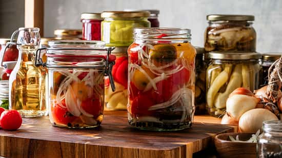 Gläser mit eingelegten Tomaten, Gurken und Zwiebeln