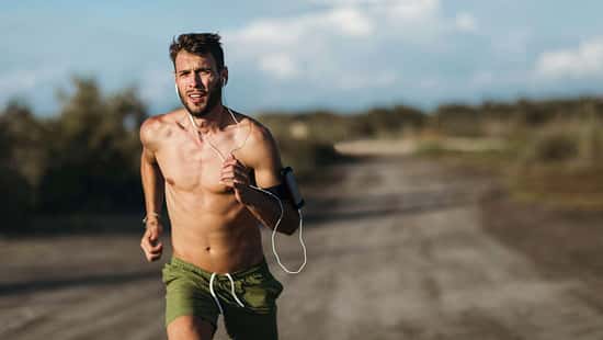 Ein junger Mann joggt oberkörperfrei in der sommerlichen Hitze
