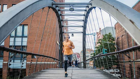 Ein Mann läuft in der Stadt auf einer Brücke