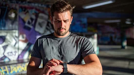 Ein Mann checkt seine Fitnessuhr