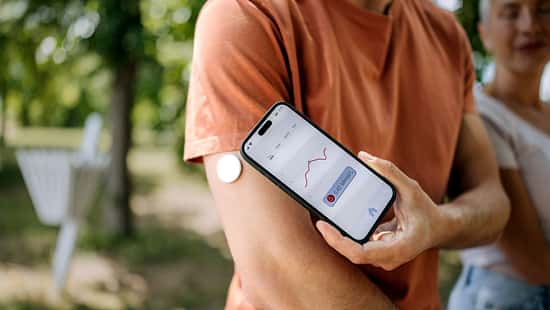 Ein Mann überprüft seinen Blutzucker mit einem Smartphone