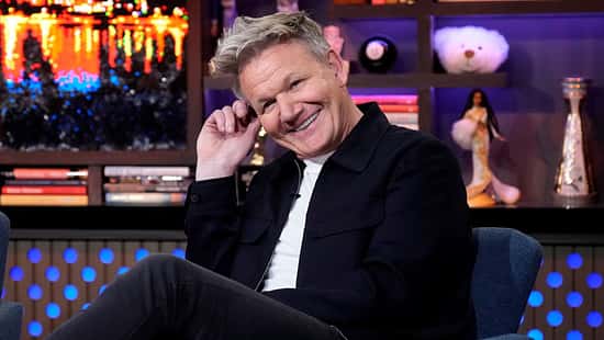 Gordon Ramsay lächelt auf einem Sessel in die Kamera live bei Andy Cohen
