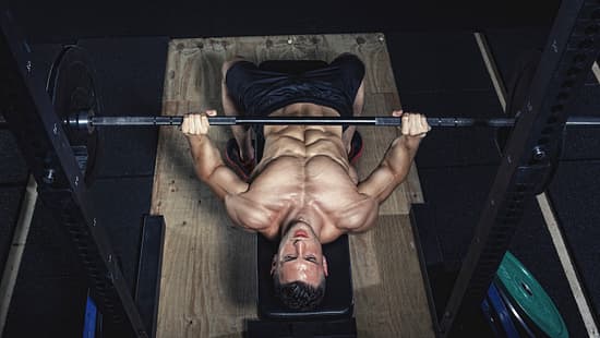 Physical athlete doing barbell bench presses