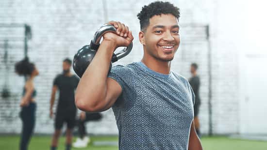 Ein junger Athlet trainiert mit einer Kettlebell im Fitnessstudio