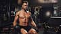 Determined young man lifting up dumbbells in the gym