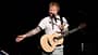 Ed Sheeran mit seiner Gitarre am Mikrofon