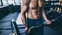 Muskulöser Mann trainiert mit Langhantel im Fitnessstudio