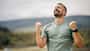 Man celebrating achievement reaching success outdoors Man celebrating achievement reaching success outdoors