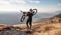 Mann trägt sein Mountain Bike auf einer Wanderung durch eine Berglandschaft Mann trägt sein Mountain Bike auf einer Wanderung durch eine Berglandschaft