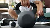 Mann nimmt eine Kettlebell in die Hand