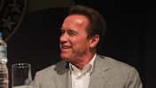 Arnold Schwarzenegger lachend auf einer Pressekonferenz in Rio.