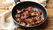 Delicious,Bacon,Slices,In,Frying,Pan,On,Wooden,Table