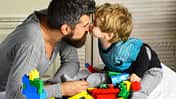 Vater und Sohn spielen mit Bauklötzen